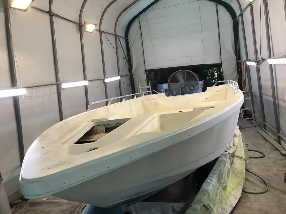 An open deck mid-refinish inside the lit paint bay